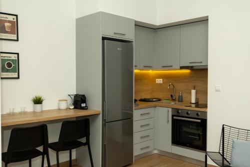 a kitchen with white cabinets and a stainless steel refrigerator at DeKolomvou in Thessaloniki