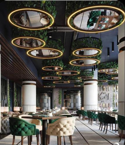 a restaurant with green chairs and a ceiling with lights at wellness at Don Borrello in Bolton