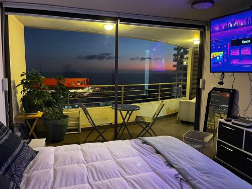 a bedroom with a bed and a view of the ocean at EXPONOR, ANTOFAGASTA APARTAMENTO DE LUJO in Antofagasta