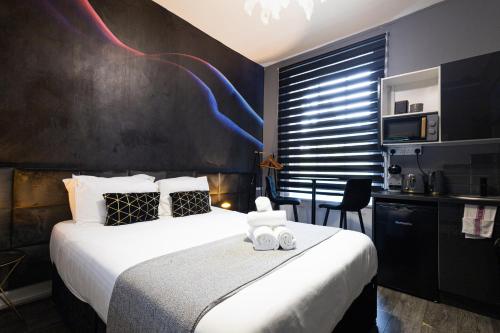 ein Hotelzimmer mit einem Bett und zwei Handtüchern in der Unterkunft Elegant 1BR Flat l Jacuzzi l Prime London Location in London
