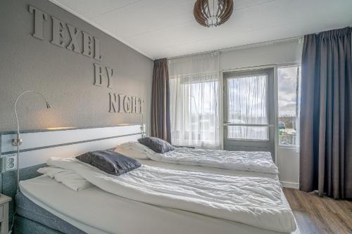 2 Betten in einem Zimmer mit Fenster in der Unterkunft Appartementencomplex Juliana 72 in De Koog