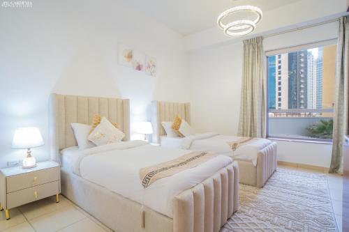 ein Hotelzimmer mit 2 Betten und einem Fenster in der Unterkunft JBR The walk Rimal 6 - 3 Bedroom plus maid 2m walking to beach in Dubai