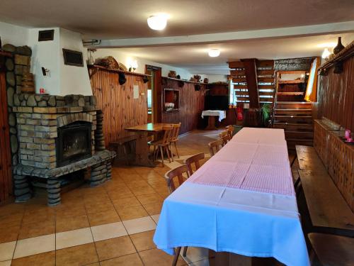 a dining room with a table and a fireplace at Chata Pod Kwiatkiem in Zawoja