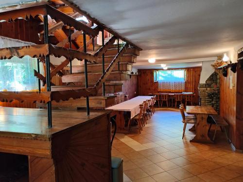 a restaurant with wooden tables and tables and chairs at Chata Pod Kwiatkiem in Zawoja