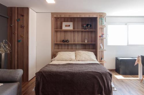 ein Schlafzimmer mit einem Bett mit einem Holzregal in der Unterkunft Precioso ático en Valencia. in Valencia