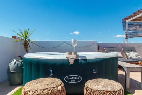 a hot tub on a patio with two stools at Precioso ático en Valencia. in Valencia