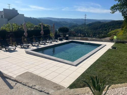 una piscina in un cortile con sedie intorno di CRASTO PAYVA DOURO NATURE a Castelo de Paiva