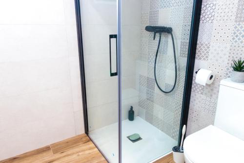 um chuveiro com uma porta de vidro na casa de banho em Precioso ático en Valencia. em Valência