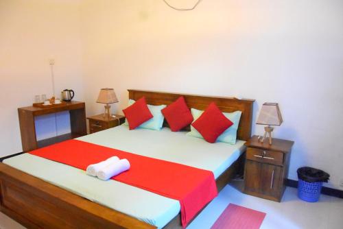 a bedroom with a bed with red and blue pillows at Cozy Homestay Kandy in Kandy