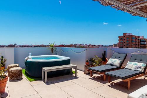 a rooftop patio with a hot tub and a table at Precioso ático en Valencia. in Valencia