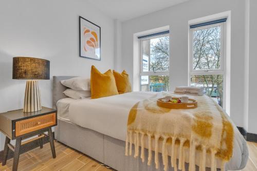 a bedroom with a bed with a bowl of fruit on it at homely - North London Luxury Apartments Finchley in Finchley