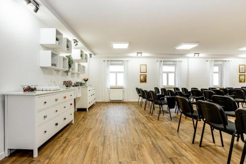 a room with chairs and desks and white cabinets at Hotel Panská in Bechyně