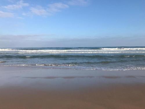 una playa con el océano y la arena y las olas en Prestigia plage des nations F3 suite parentale, chambre 2 lits, salon séjour terrasse, 2 salle de bain, en Sidi Bouqnadel