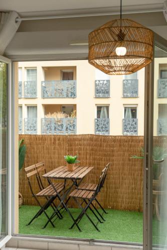une table et des chaises sur une terrasse avec une fenêtre dans l'établissement Jungle Paradise-Disney-Free Parking, à Montévrain