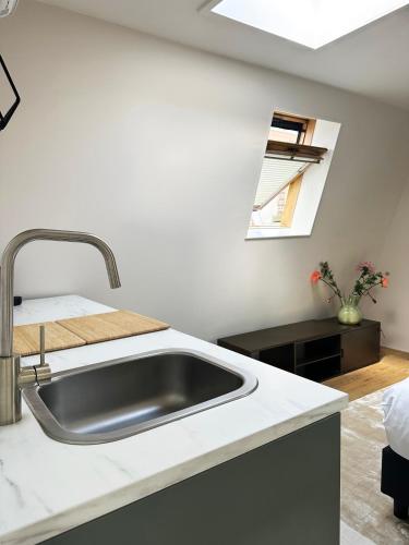 a kitchen counter with a sink and a window at Rembrandtplein Apartments in Amsterdam