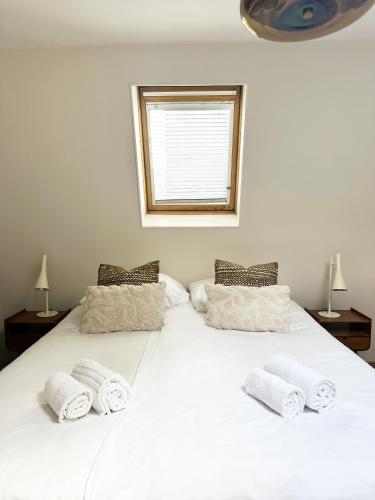 a large white bed with three towels on it at Rembrandtplein Apartments in Amsterdam