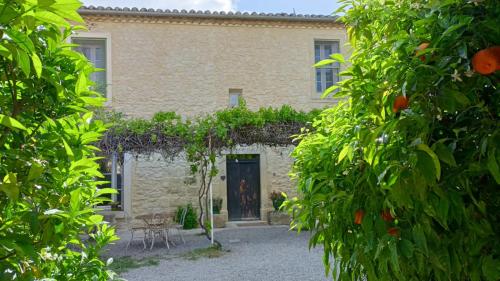 une maison en pierre avec une porte à travers deux arbres dans l'établissement La Taniere 16 couchages, à Vergèze