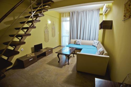 - un salon avec un canapé et un escalier dans l'établissement Хотел и Вили Марая, à Tsarévo