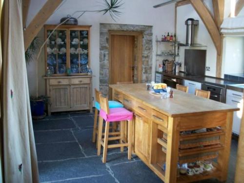 a kitchen with a wooden island with a pink seat at Mount Coggill in Kilkenny