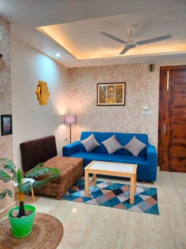 uma sala de estar com um sofá azul e uma mesa em Blue Heart Home~1BHK Luxury & Cosy Flat in Tapovan em Rishikesh