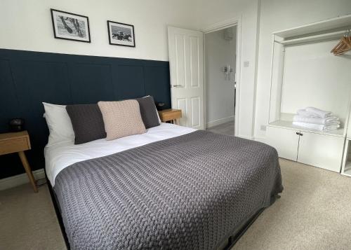 um quarto com uma cama grande e uma cabeceira azul em Apartment 3 St Georges em Cheltenham