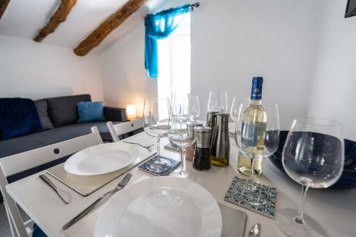 a dining table with wine glasses and a couch at Rambla Retreats Apartment Azul with shared pool & hot tub in Oria in Oria