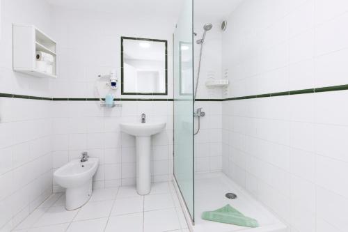Baño blanco con lavabo y aseo en Apartamentos Erika - Adults Only, en Corralejo