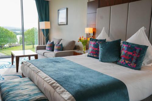 エニスキレンにあるマナー ハウス カントリー ホテルの大きなベッドとソファが備わるホテルルームです。