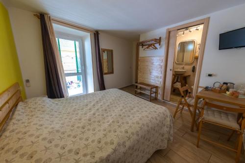 a bedroom with a bed and a desk and a window at Ca' de Baran in Manarola