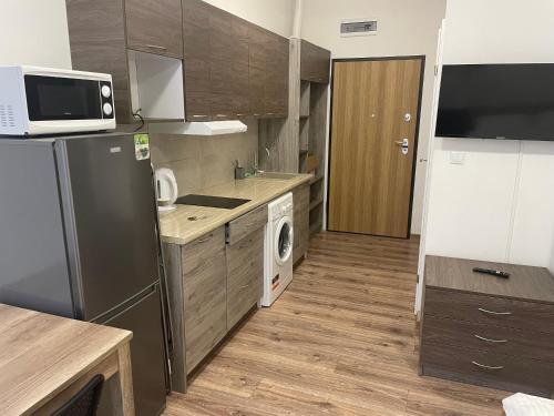 eine Küche mit einem Kühlschrank und einer Waschmaschine in der Unterkunft Apartamenty 3 Kraków Podgórze in Krakau