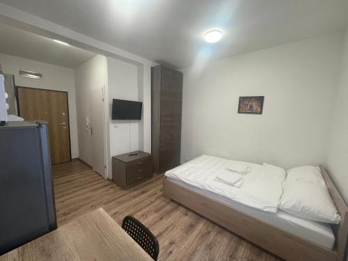 Schlafzimmer mit einem Bett, einem Tisch und einem TV in der Unterkunft Apartamenty 3 Kraków Podgórze in Krakau