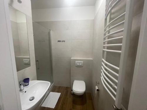 ein weißes Bad mit einem WC und einem Waschbecken in der Unterkunft Apartamenty 3 Kraków Podgórze in Krakau