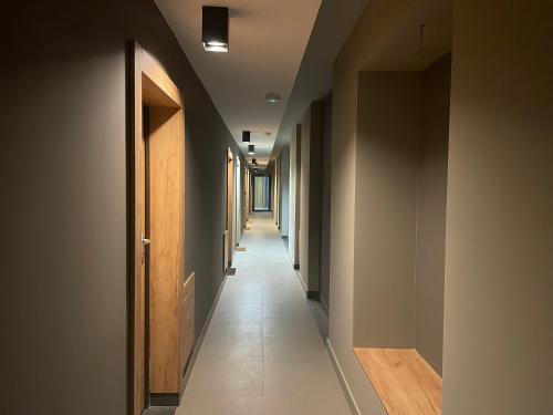 einen Flur mit einem langen Korridor mit vielen Türen in der Unterkunft Apartamenty 3 Kraków Podgórze in Krakau