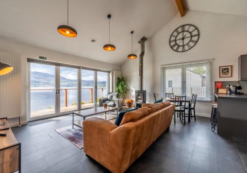 a living room with a large couch and a table at Shoreland Lodges - Cherry Lodge in Fort Augustus