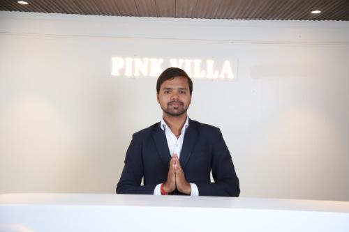a man standing at a podium with his hands up at Pink Villa Boutique Hotel in Meerut