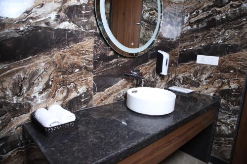 a bathroom with a sink and a mirror at Pink Villa Boutique Hotel in Meerut