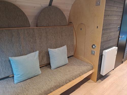 duas almofadas sentadas num banco num quarto em Celtic Minor Pods em Ystalyfera