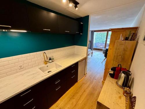 a kitchen with a sink and a counter top at Modern LAAX apt, Swimming Pools, Wellness & Tennis in Laax