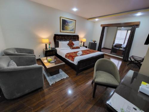 a bedroom with a bed and a living room at Grand Millennium Hotel in Lahore