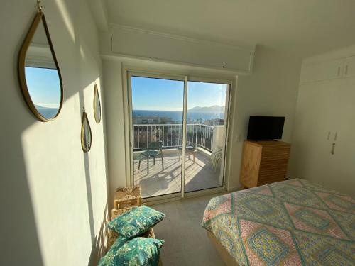 une chambre avec un lit et une vue sur un balcon dans l'établissement Vue mer à couper le souffle - nouveau entièrement rénové, à Cannes