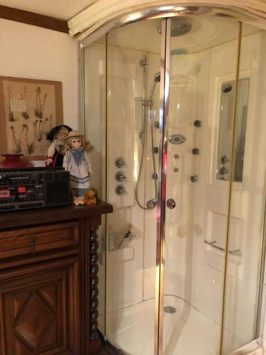 une douche dans une salle de bain avec deux poupées debout à côté dans l'établissement Yufan, à La Ville-du-Bois