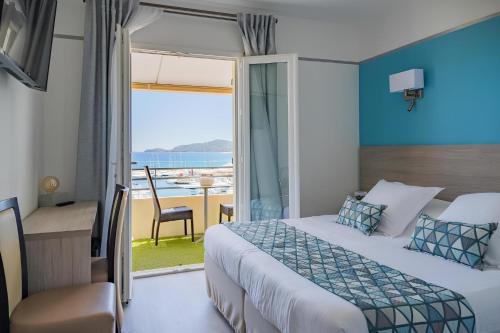 a bedroom with a bed and a view of the ocean at Le Rabelais in Le Lavandou