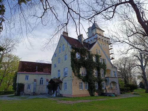 un grand bâtiment avec une tour en haut dans l'établissement Zamek Nowęcin, à Łeba