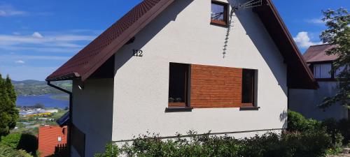 a house with a window on the side of it at Domek z widokiem na jezioro Rożnowskie 