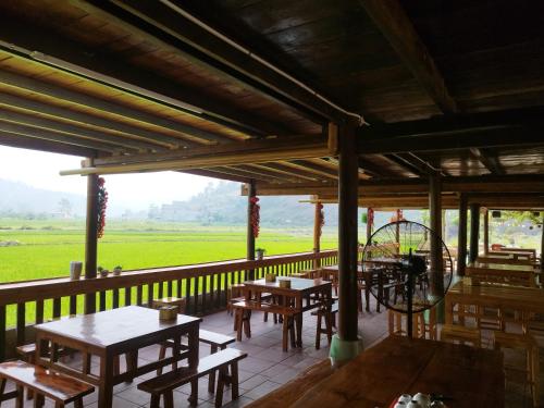 a restaurant with tables and chairs on a balcony at Homestay Tommy House in Ha Giang