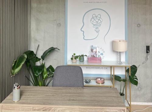 une table avec une chaise et un bureau avec des plantes dans l'établissement Smuk arkitekttegnet hus i Newyorker-stil, à Copenhague