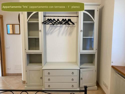 a closet with a white cabinet with shelves at Country House Foglie d'erba in Calavino