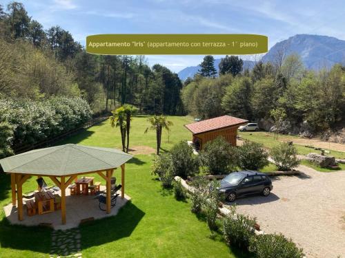 a house with a gazebo and a car in a yard at Country House Foglie d'erba in Calavino