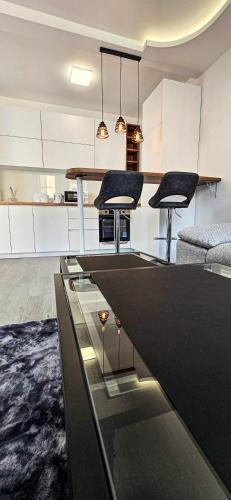 a kitchen with a table and two stools at Apartman Spaß in Šabac