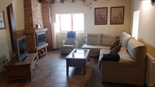 sala de estar con sofá y TV en El Tinao de la Hiruela (Entremelojos), en La Hiruela